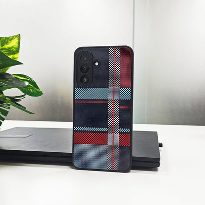 Phone case with plaid pattern on a white surface with a plant and laptop in the background